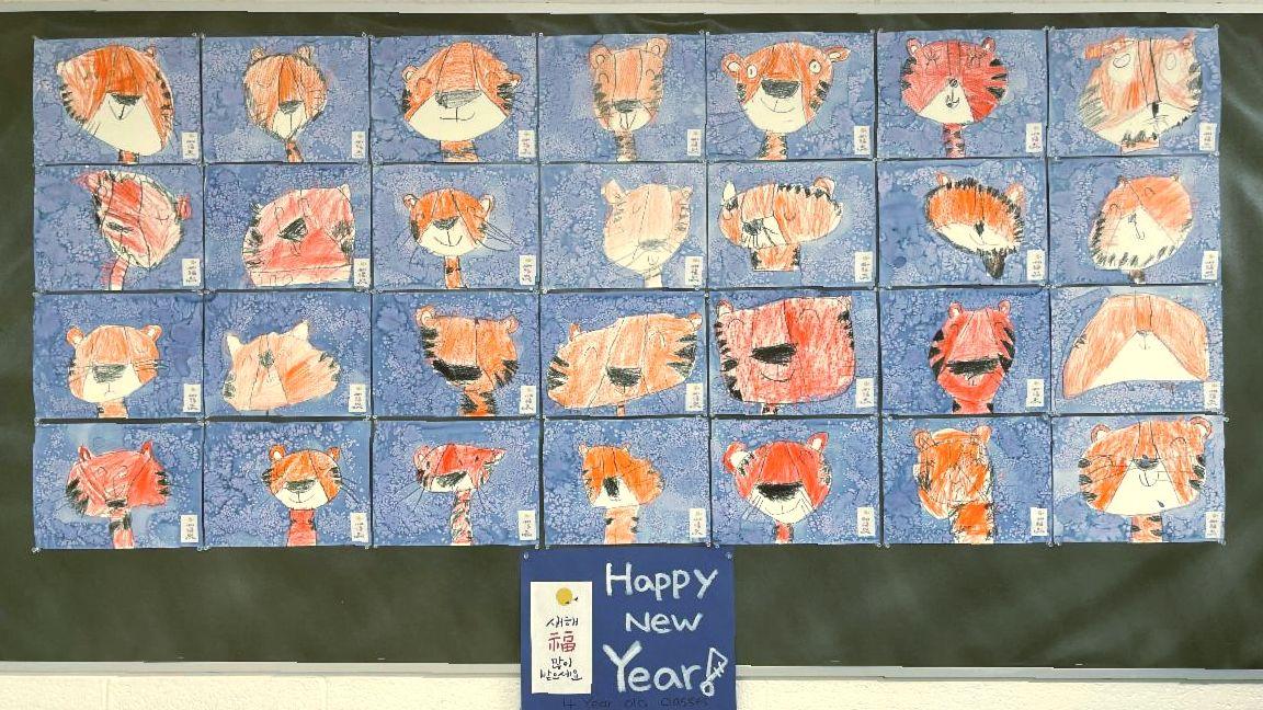 A display of multiple student paintings of a tiger's face in celebration of the lunar new year, year of of the tiger.