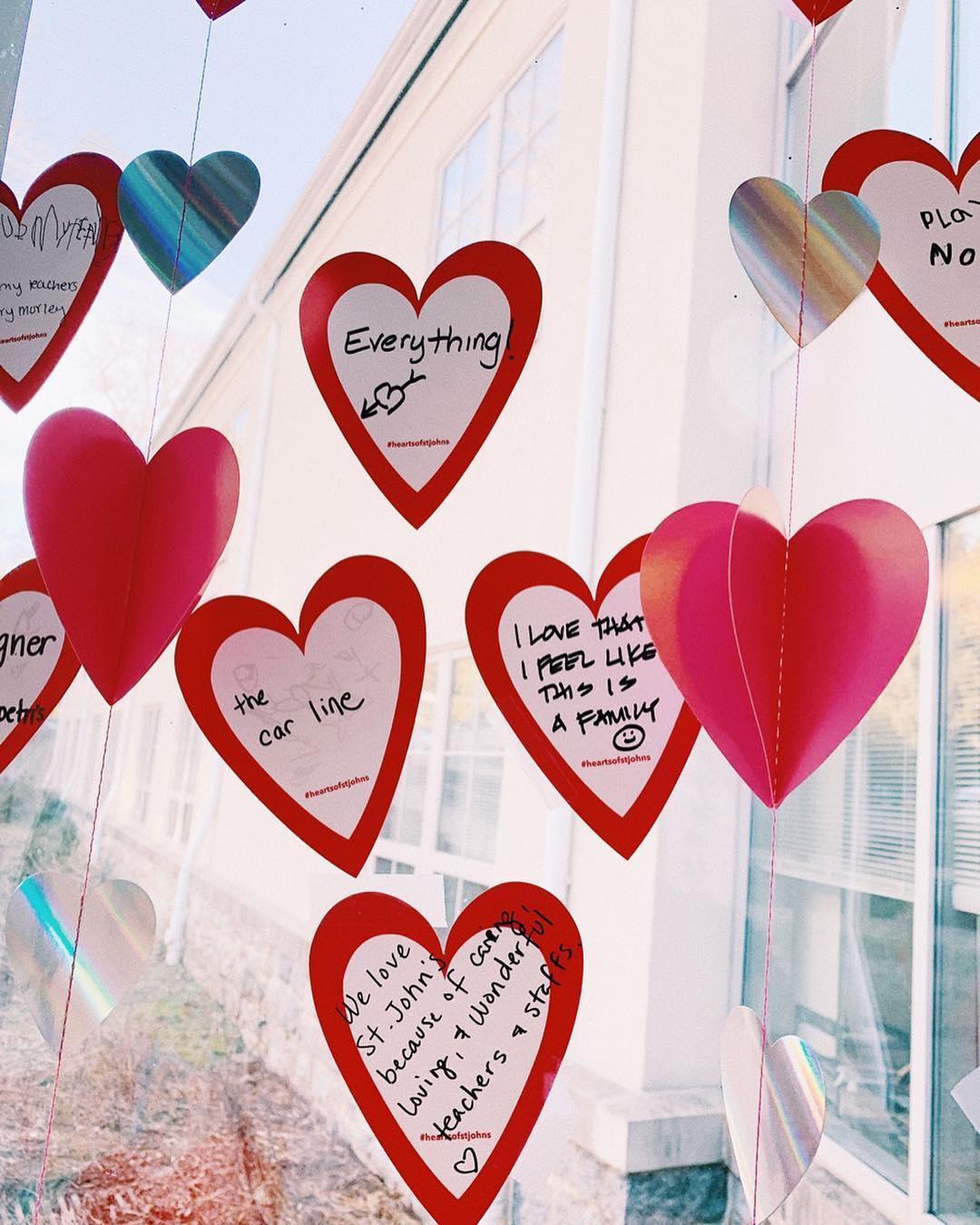 Paper hearts taped on a window with comments about what people love about St. John's