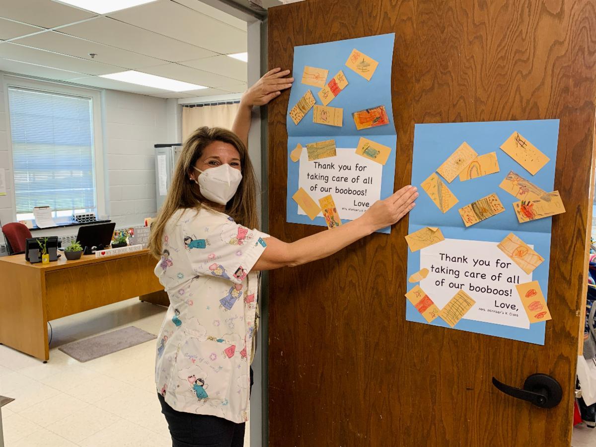 Nurse holding appreciation posters from students