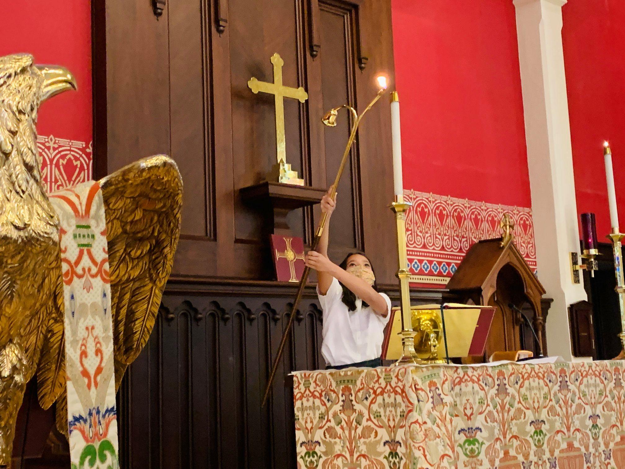 Student acolyte lighting altar candles