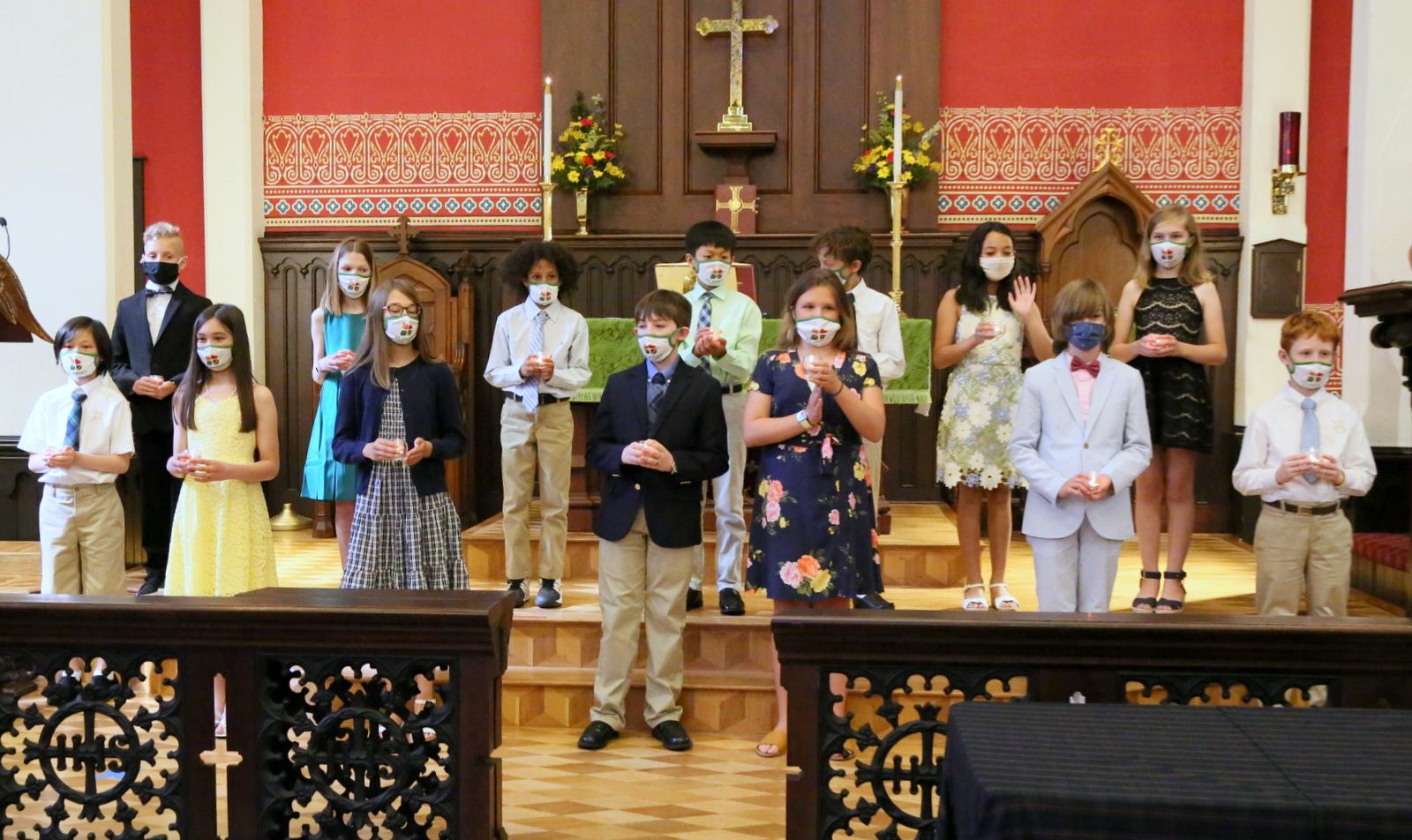 5th grade graduates standing at church altar as a group