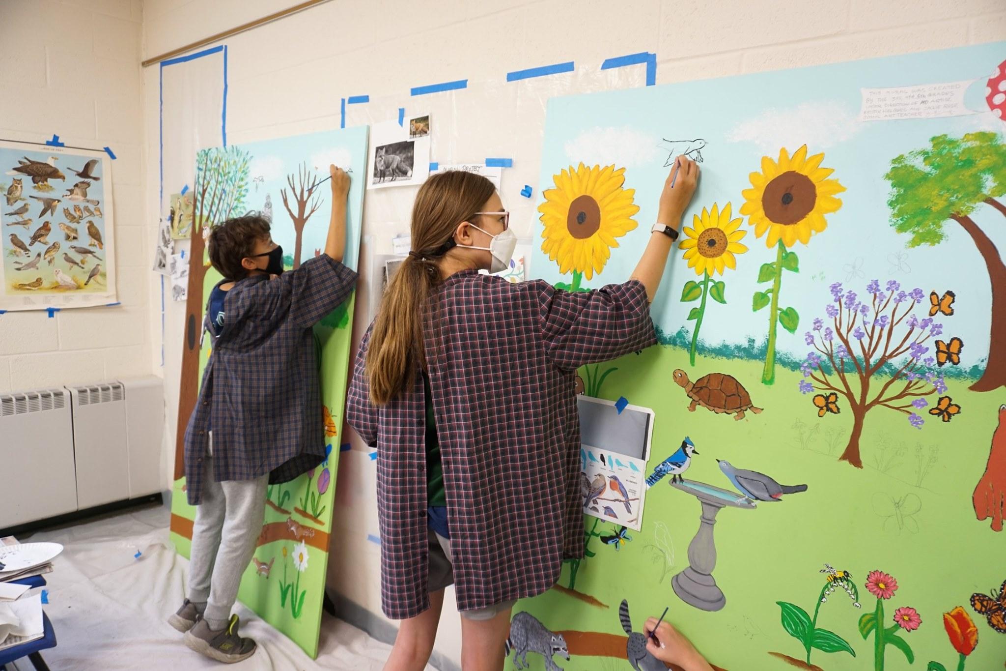 a boy and a girl painting the mural 